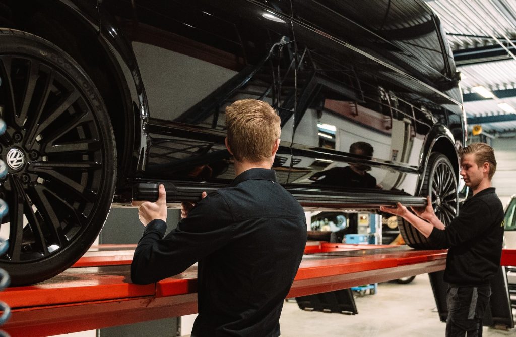 Twee monteurs werken samen aan een bedrijfswagen bij Autobedrijf van den Berg