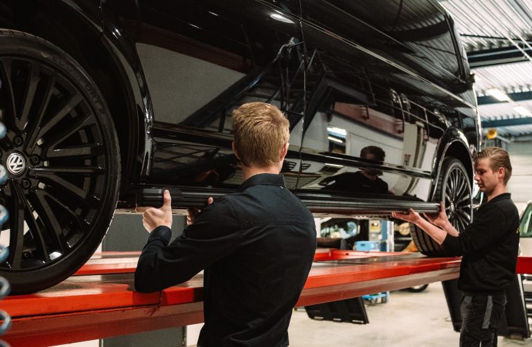 Twee monteurs werken samen aan een bedrijfswagen bij Autobedrijf van den Berg